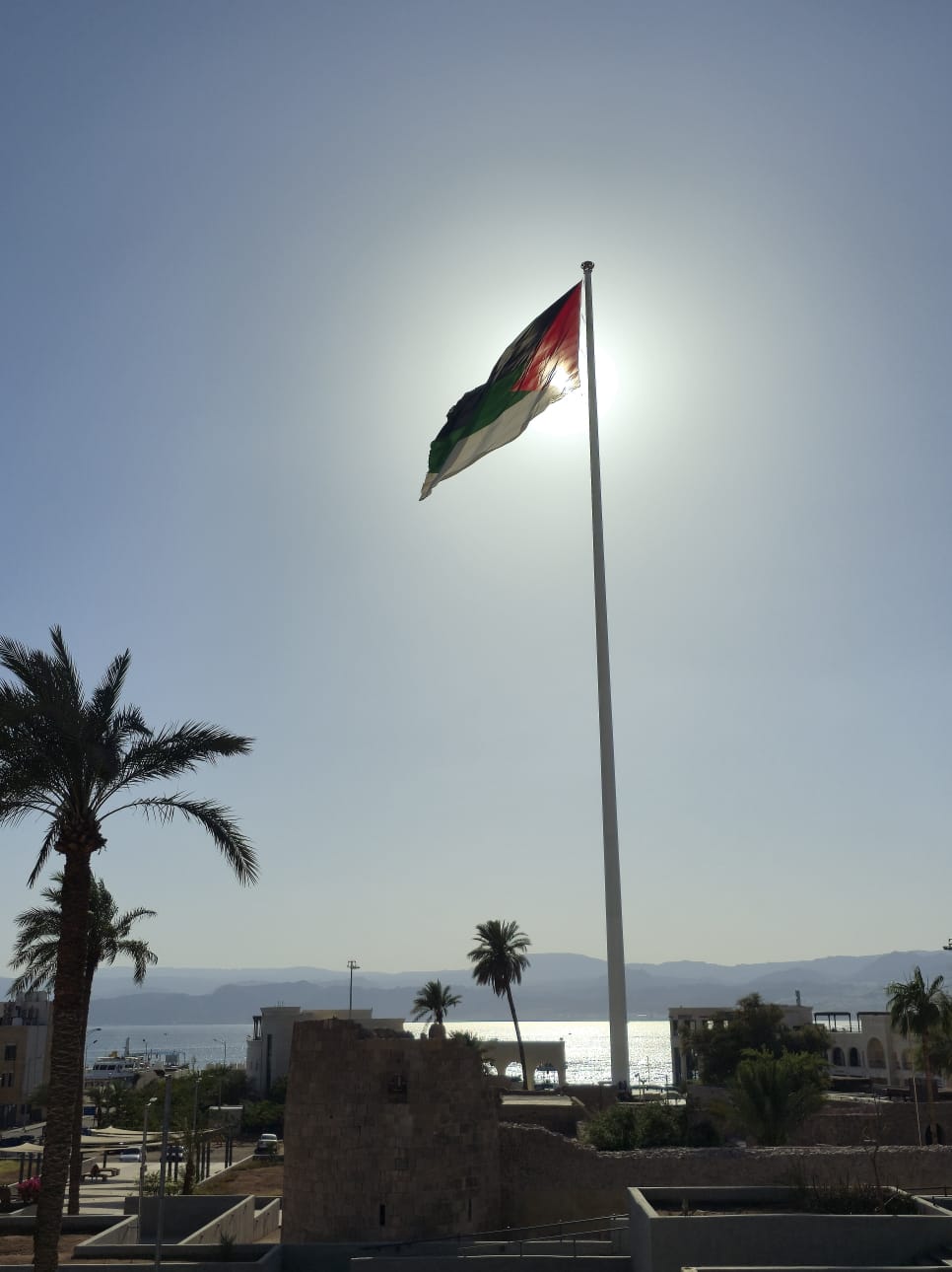 علم الثورة يخفق في سماء العقبة تداعبه رياحها وتتخلله خيوط شمسها لترسم جمالا تزدان به المدينة الساحلية
